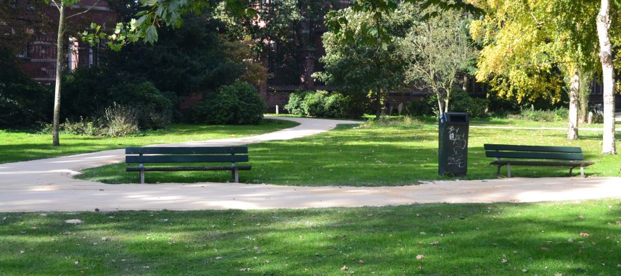 Kronkelend pad van Nobre Cál door een groene parkzone met bankjes