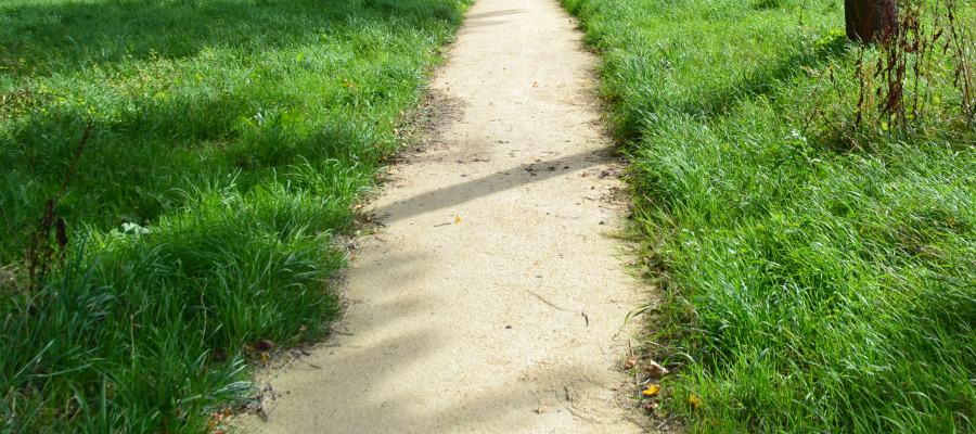 Nobre Cál halfverharding: minimaal onderhoud, maximaal plezier. Smal, goed onderhouden wandelpad van halfverharding door grasrijke omgeving
